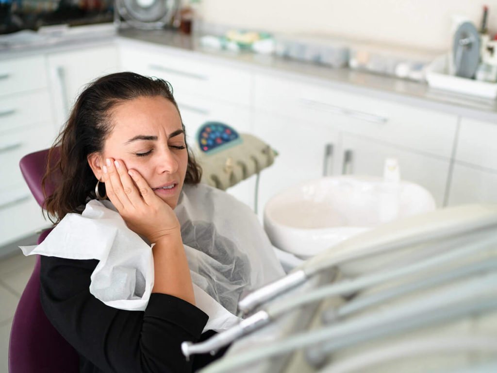 Patient holding her face in pain