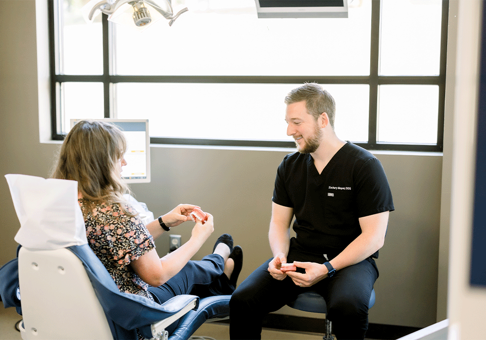 Dr. Meyer sitting chair side with a patient